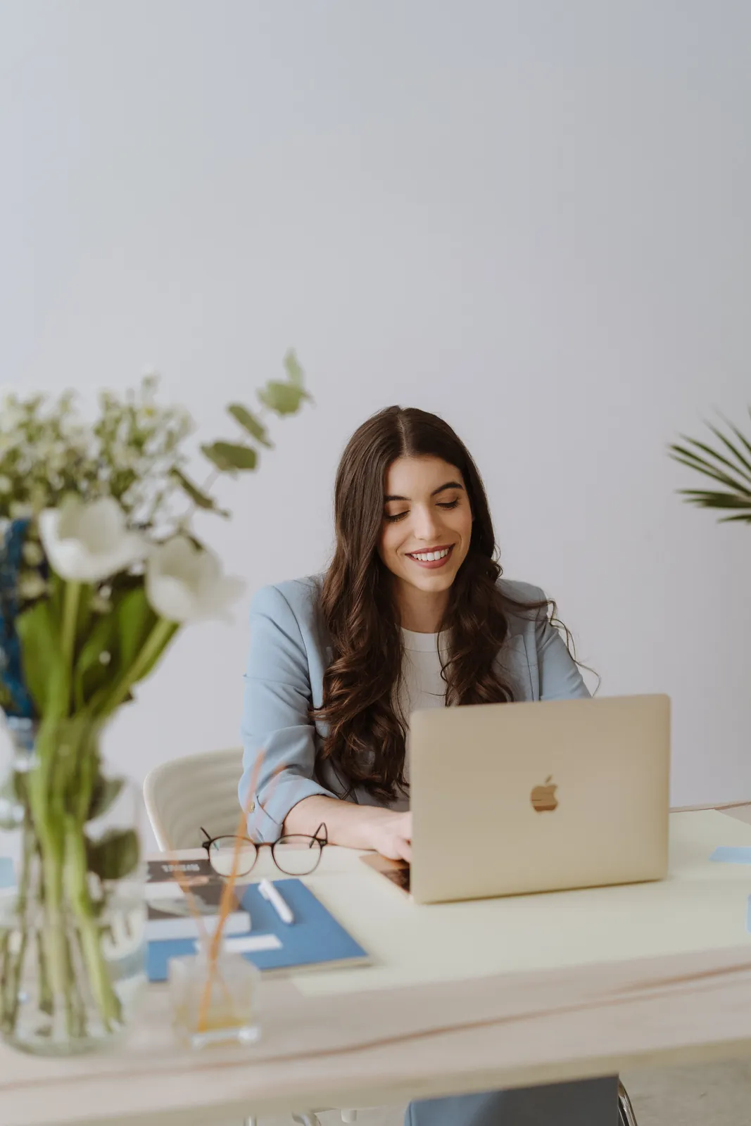 Silvia Nieto, correctora editorial, trabajando en su escritorio con portátil y flores