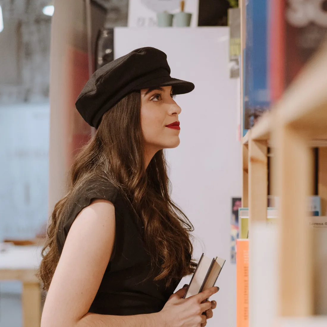 Silvia Nieto, editora y traductora, con libros junto a una estantería de librería